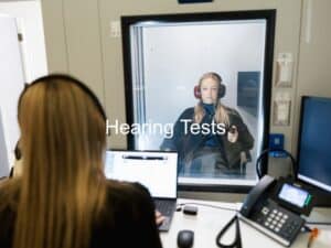 patient sitting in a soundbooth taking a hearing test
